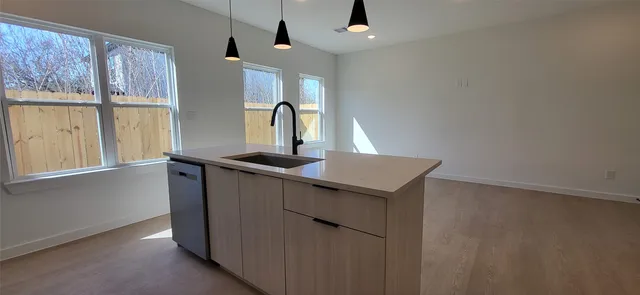 a kitchen with a sink a window and stainless steel appliances