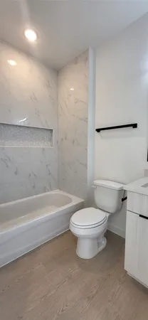 a white toilet sitting next to a bath tub and a shower