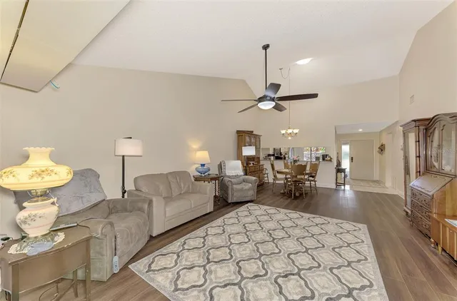 a view of a dining room with furniture a chandelier and wooden floor