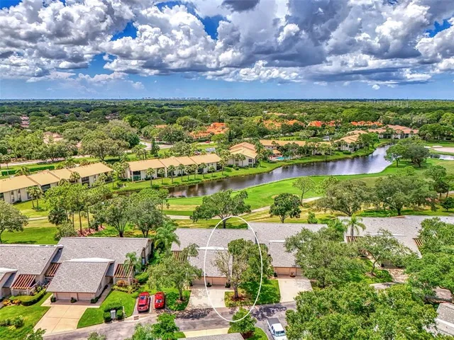 an aerial view of residential houses with outdoor space and lake view