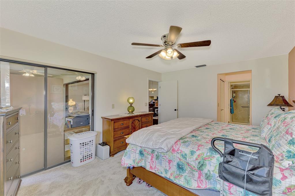4521 Kingsmere, Unit 6 Sarasota, FL 34235 - Photo 24 of 42 a bedroom with a bed and a chandelier