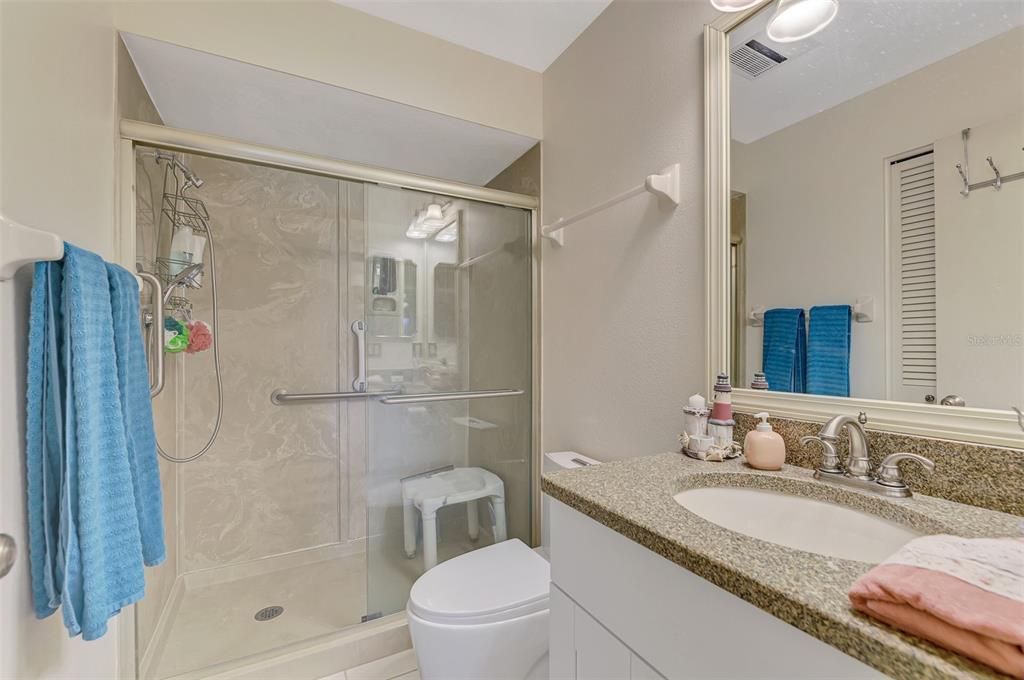 4521 Kingsmere, Unit 6 Sarasota, FL 34235 - Photo 26 of 42 a bathroom with a granite countertop sink toilet and shower