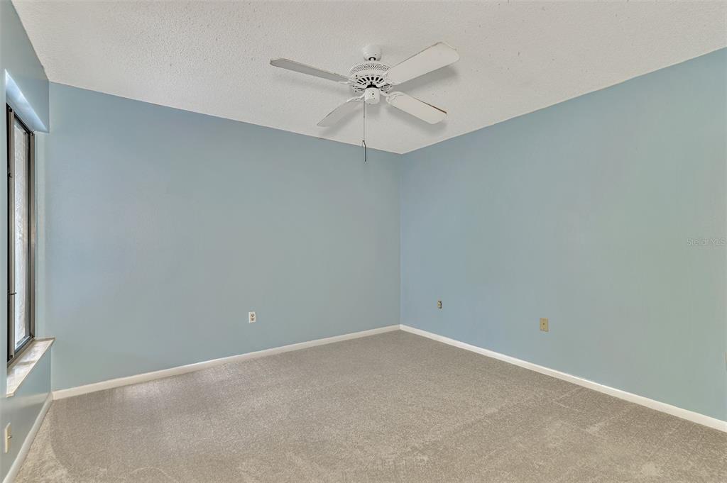 4521 Kingsmere, Unit 6 Sarasota, FL 34235 - Photo 27 of 42 an empty room with a ceiling fan and a window