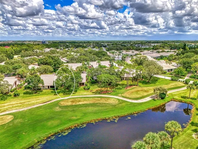 an aerial view of a house with a yard and lake view