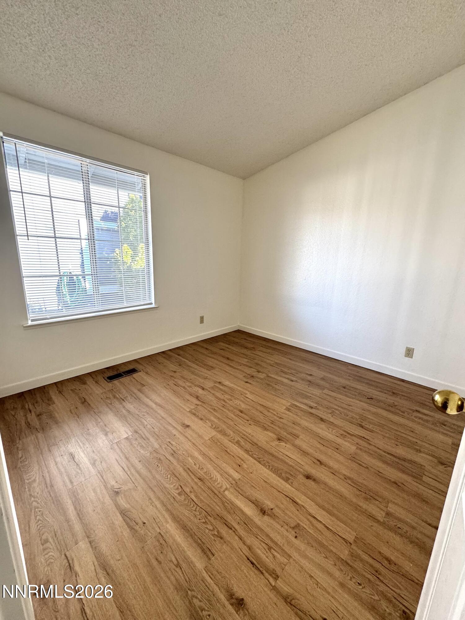 6052 Walnut Creek Road Reno, NV 89523 - Photo 11 of 11 an empty room with wooden floor and windows