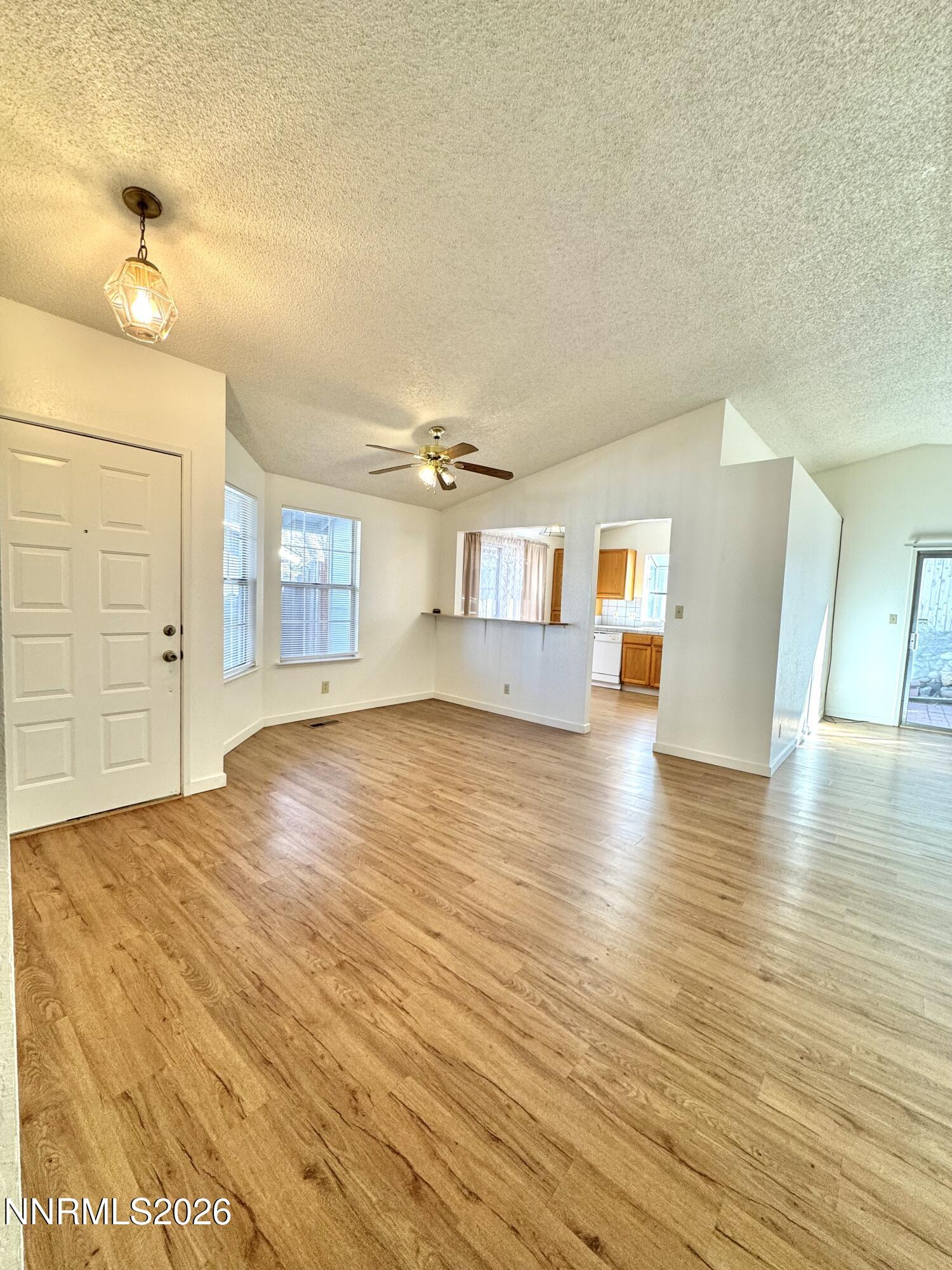 6052 Walnut Creek Road Reno, NV 89523 - Photo 4 of 11 a view of a livingroom with wooden floor and a kitchen