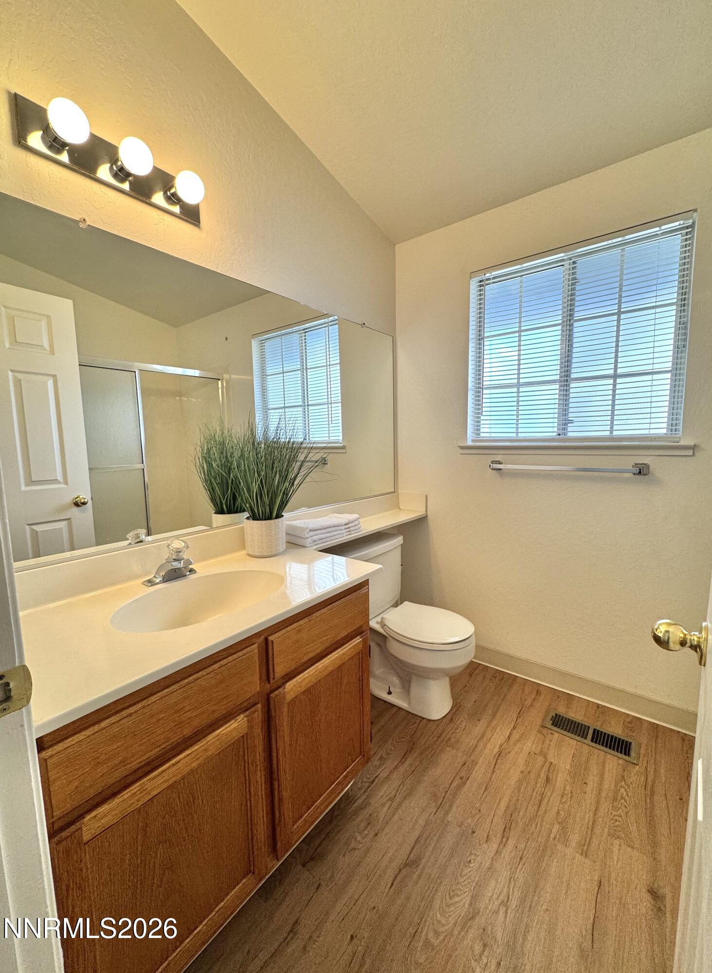 6052 Walnut Creek Road Reno, NV 89523 - Photo 10 of 11 a bathroom with a granite countertop sink toilet and mirror