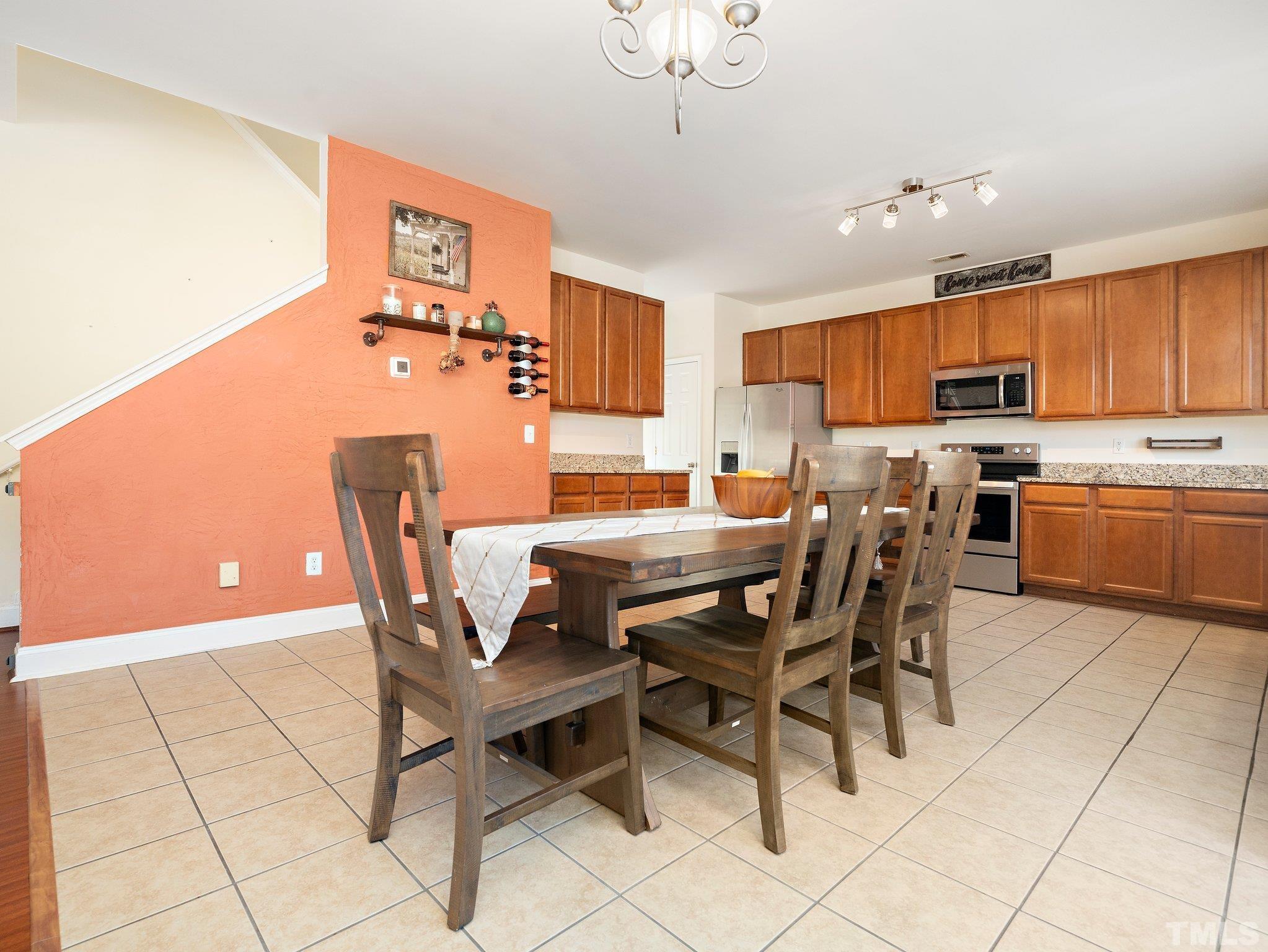 8803 Elizabeth Bennet Place Raleigh, NC 27616 - Photo 12 of 23 a view of a dining room with furniture and a chandelier
