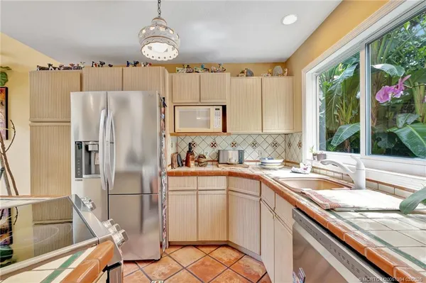 a kitchen with granite countertop a sink appliances and cabinets