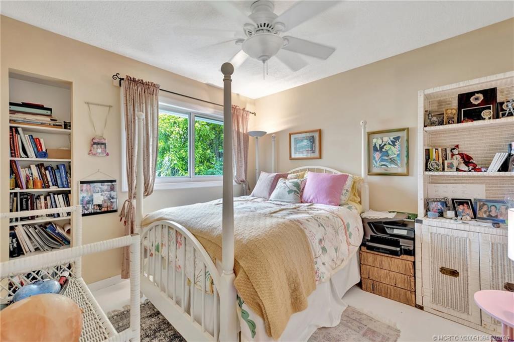 221 Coconut Avenue Stuart, FL 34996 - Photo 14 of 20 a bed room with a bed and a book shelf