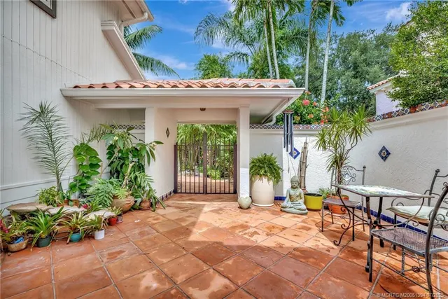 a view of a white building with a large window and potted plants