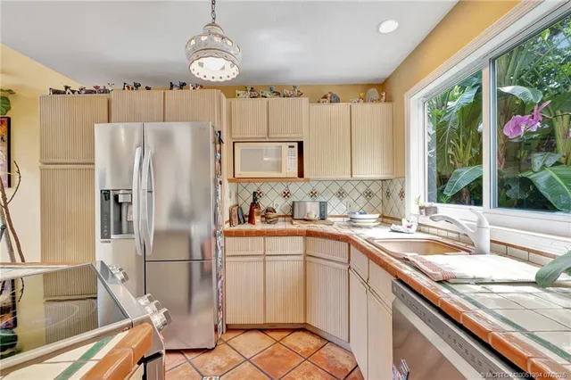 a kitchen with granite countertop a sink appliances and cabinets