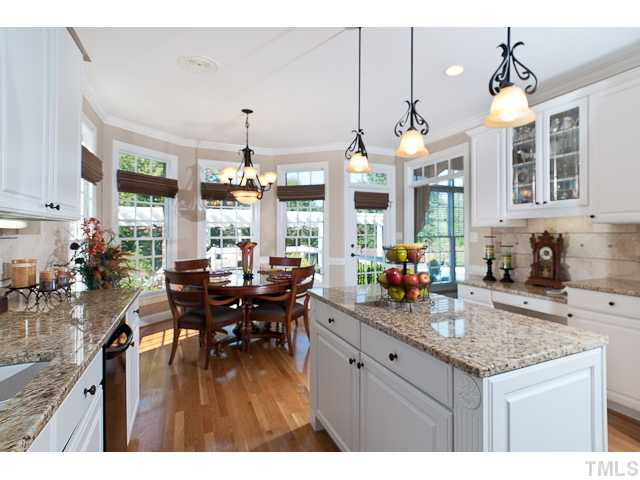 502 Mason Road Durham, NC 27712 - Photo 11 of 25 a kitchen with a granite countertop stove a sink dishwasher a dining table and chairs with wooden floor