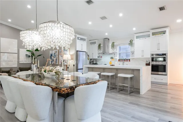 a large white kitchen with lots of counter space wooden floor and appliances