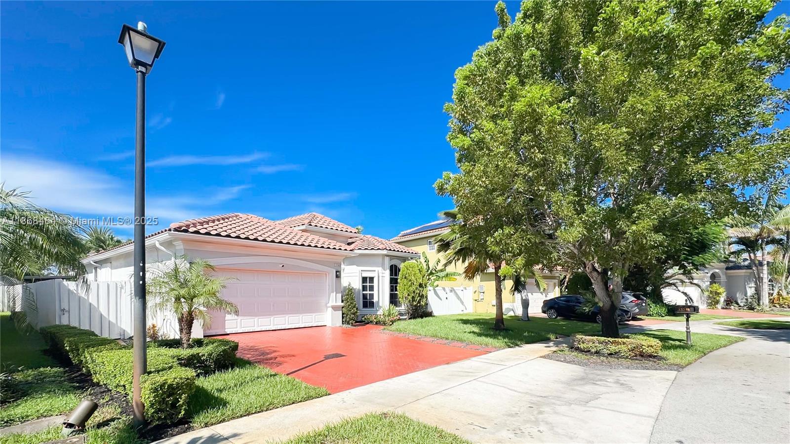 13348 Southwest 52nd Street Miramar, FL 33027 - Photo 2 of 48 a front view of a house with a yard and potted plants