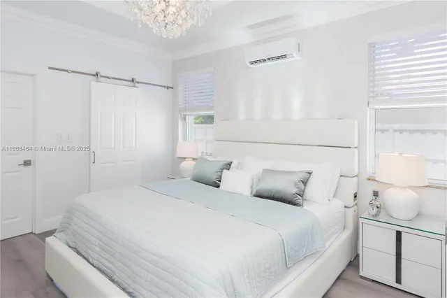 a bedroom with a large bed and a chandelier