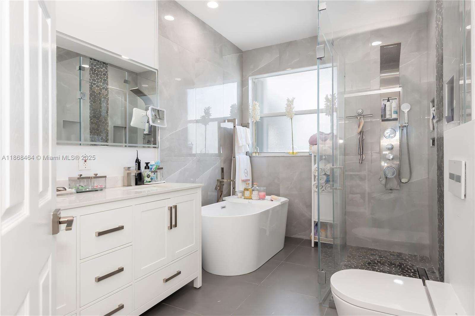 13348 Southwest 52nd Street Miramar, FL 33027 - Photo 33 of 48 a bathroom with a double vanity sink toilet mirror and shower