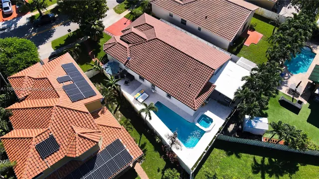 an aerial view of residential houses with outdoor space and swimming pool