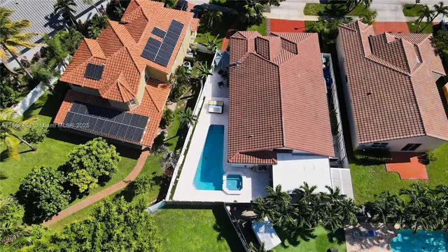 an aerial view of a house with a garden and lake view