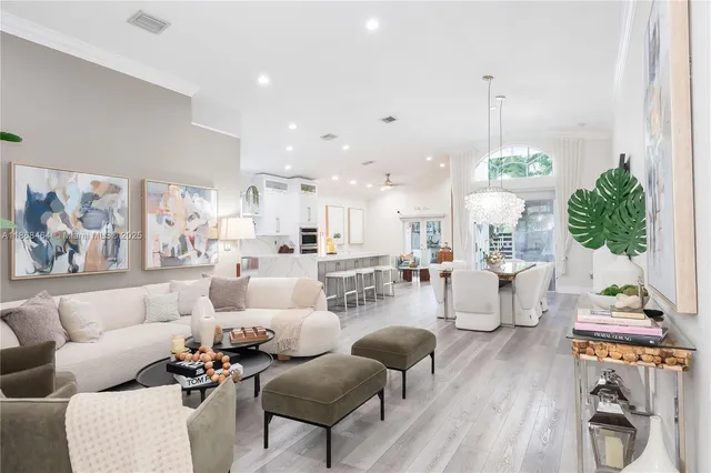 a living room with furniture a wooden floor and a potted plant