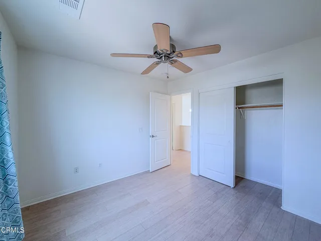 wooden floor in an empty room with a fan