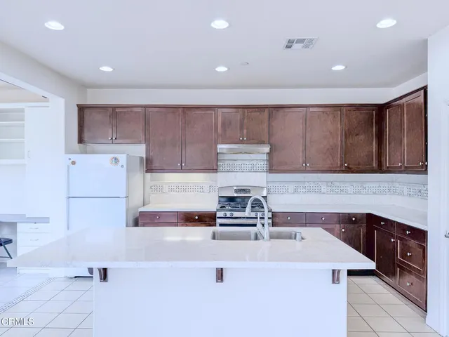 a kitchen with a sink a stove and cabinets