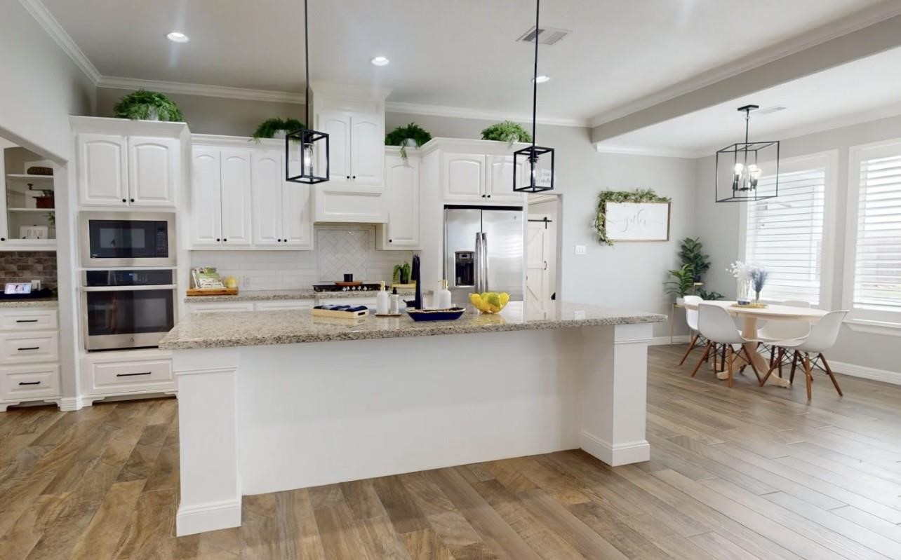 1508 North Blue Bonnet Lane Angleton, TX 77515 - Photo 4 of 11 a kitchen with stainless steel appliances granite countertop a refrigerator a oven a sink a dining table and chairs with wooden floor