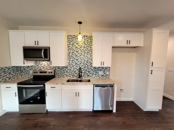 a kitchen with stainless steel appliances granite countertop a stove and a microwave