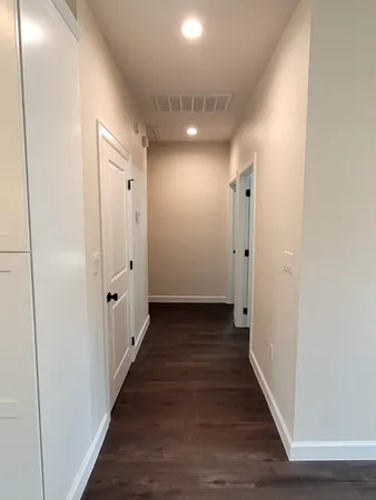 a view of a hallway with wooden floor