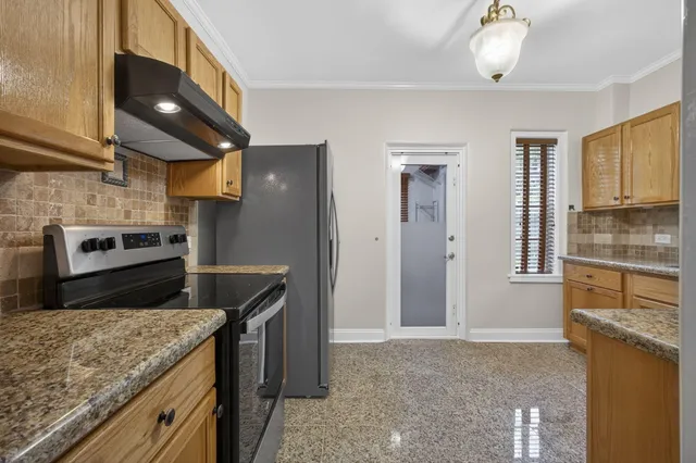 a kitchen with stainless steel appliances granite countertop a refrigerator a stove and a sink