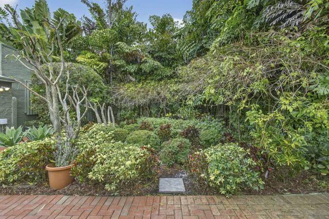 a front view of a house with a yard and potted plants