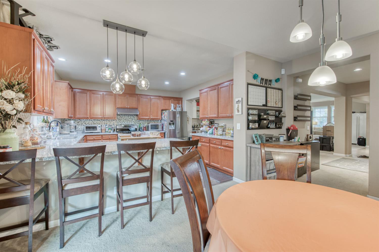 677 Everglade Avenue Clovis, CA 93619 - Photo 12 of 29 a kitchen with kitchen island a dining table chairs stainless steel appliances and cabinets