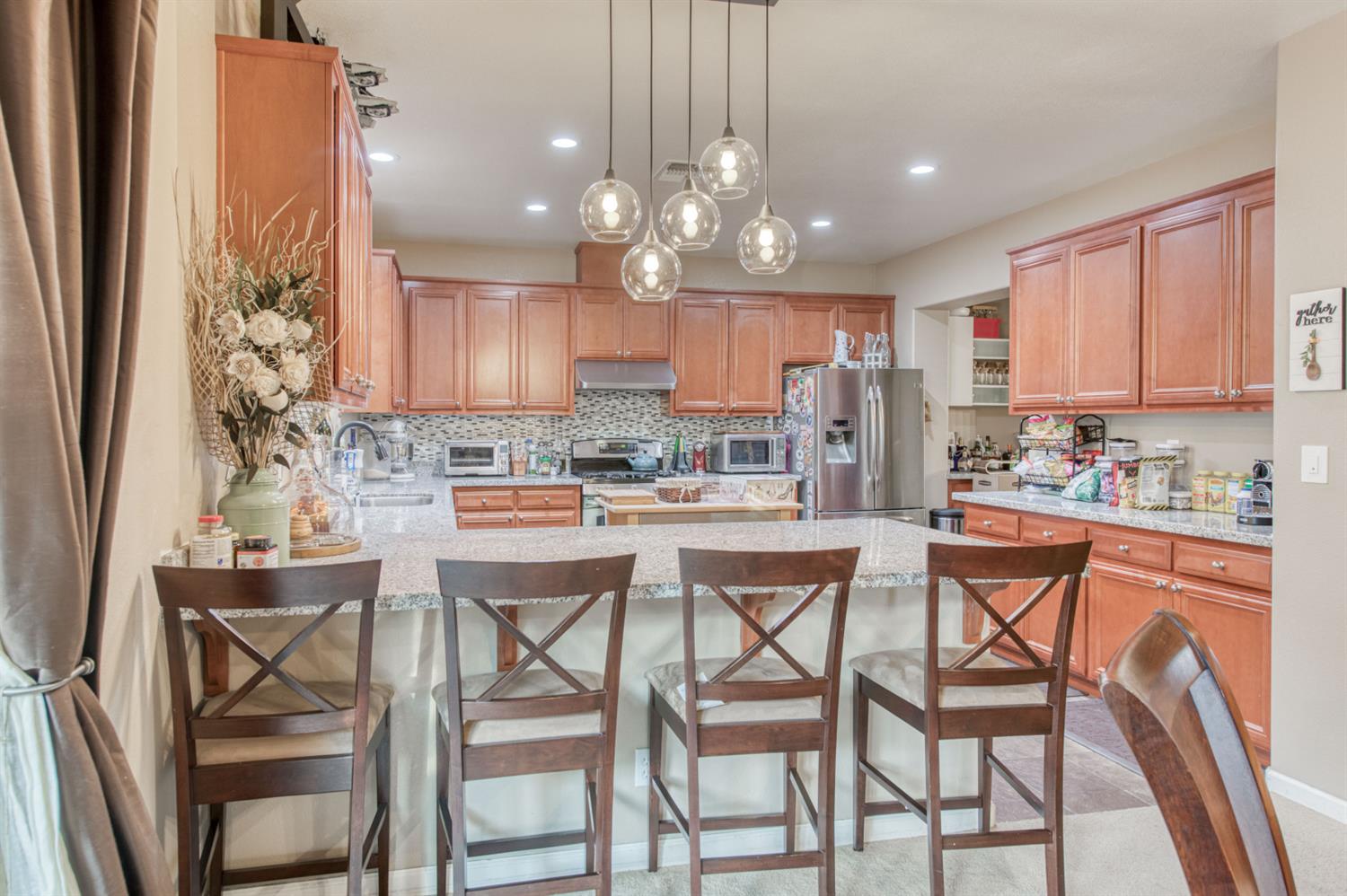 677 Everglade Avenue Clovis, CA 93619 - Photo 13 of 29 a kitchen with kitchen island granite countertop wooden floors and white cabinets