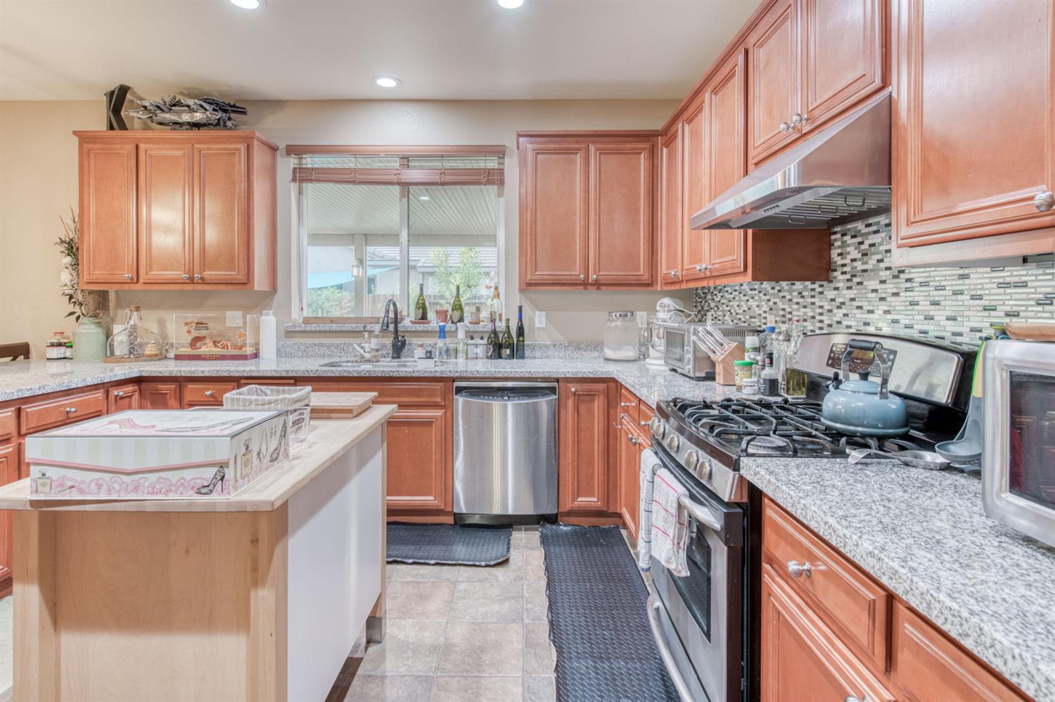677 Everglade Avenue Clovis, CA 93619 - Photo 14 of 29 a kitchen with stainless steel appliances granite countertop a sink stove and cabinets