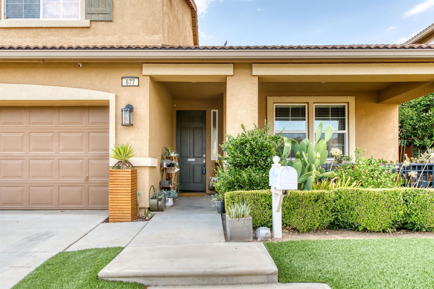 677 Everglade Avenue Clovis, CA 93619 - Photo 5 of 29 a front view of a house with a garden and plants