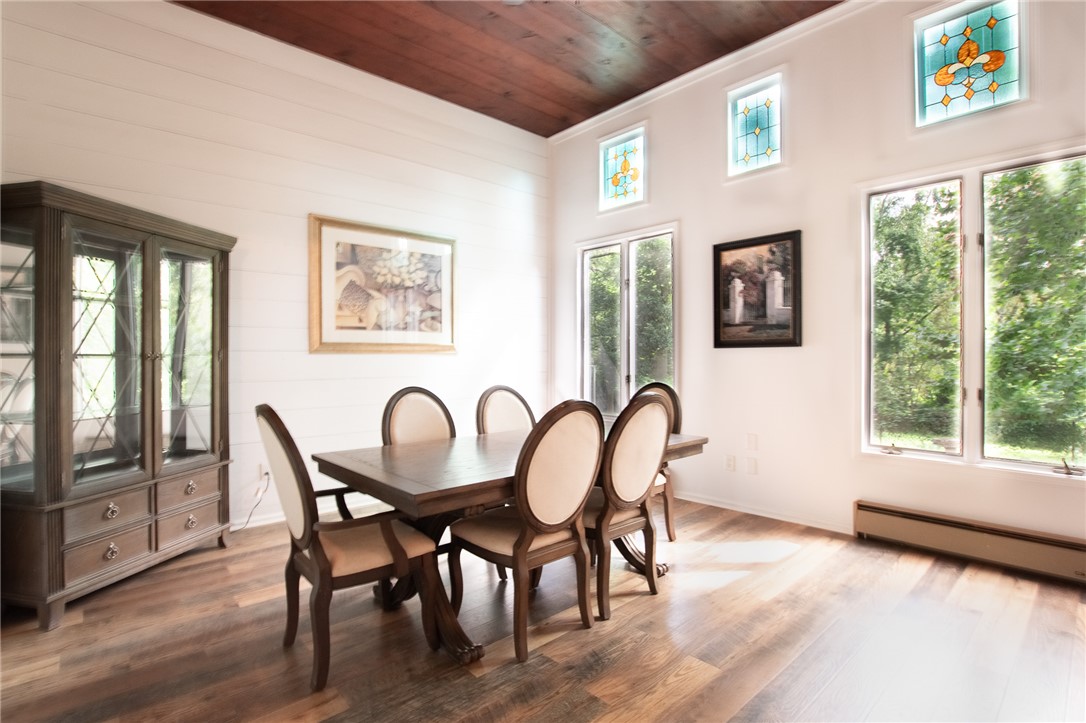 200 Chenault Road Townville, SC 29689 - Photo 10 of 47 Hardwood flooring flows through this formal dining room, illuminated by high windows and a rustic wooden ceiling.
