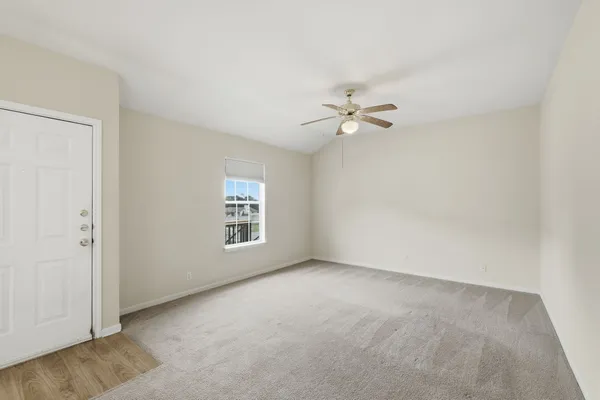 an empty room with fan and windows