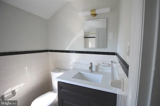 a bathroom with a sink toilet and mirror