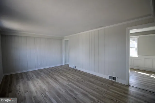 a view of an empty room with wooden floor