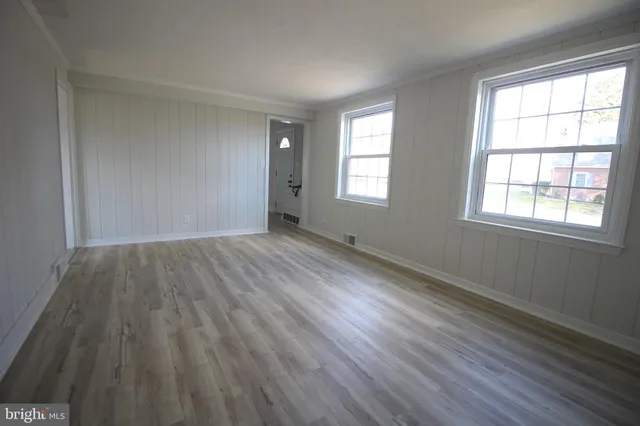a view of a room with wooden floor and windows