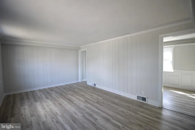 a view of an empty room with wooden floor
