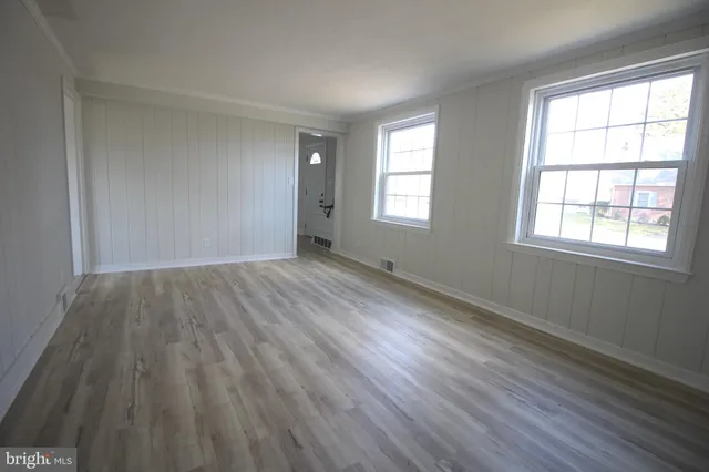 a view of a room with wooden floor and windows