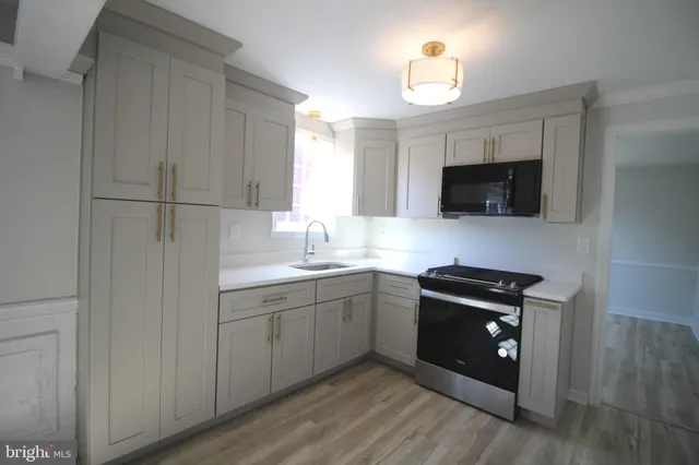 a kitchen with a sink a stove and microwave