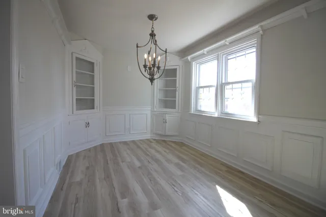 a view of empty room with wooden floor and window