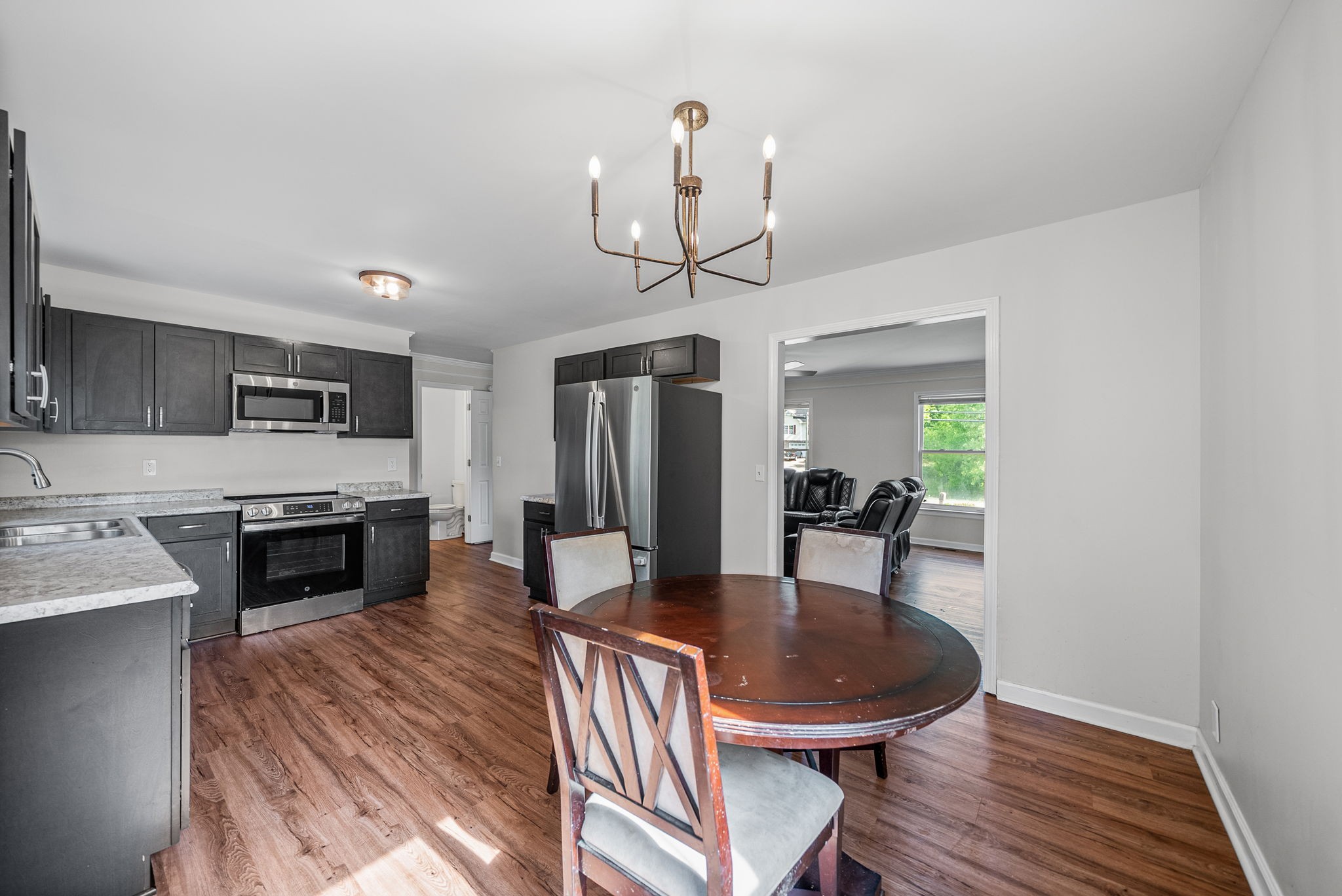 1706 Hazelwood Road Clarksville, TN 37042 - Photo 8 of 31 a dining room with furniture a chandelier and wooden floor