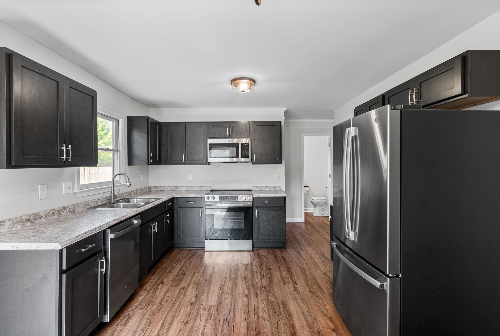 1706 Hazelwood Road Clarksville, TN 37042 - Photo 9 of 31 a kitchen with stainless steel appliances granite countertop a refrigerator a sink dishwasher a stove and white countertops with wooden floor