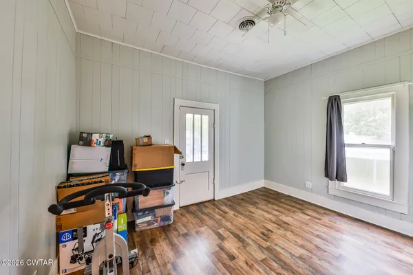 a area with wooden floor and windows