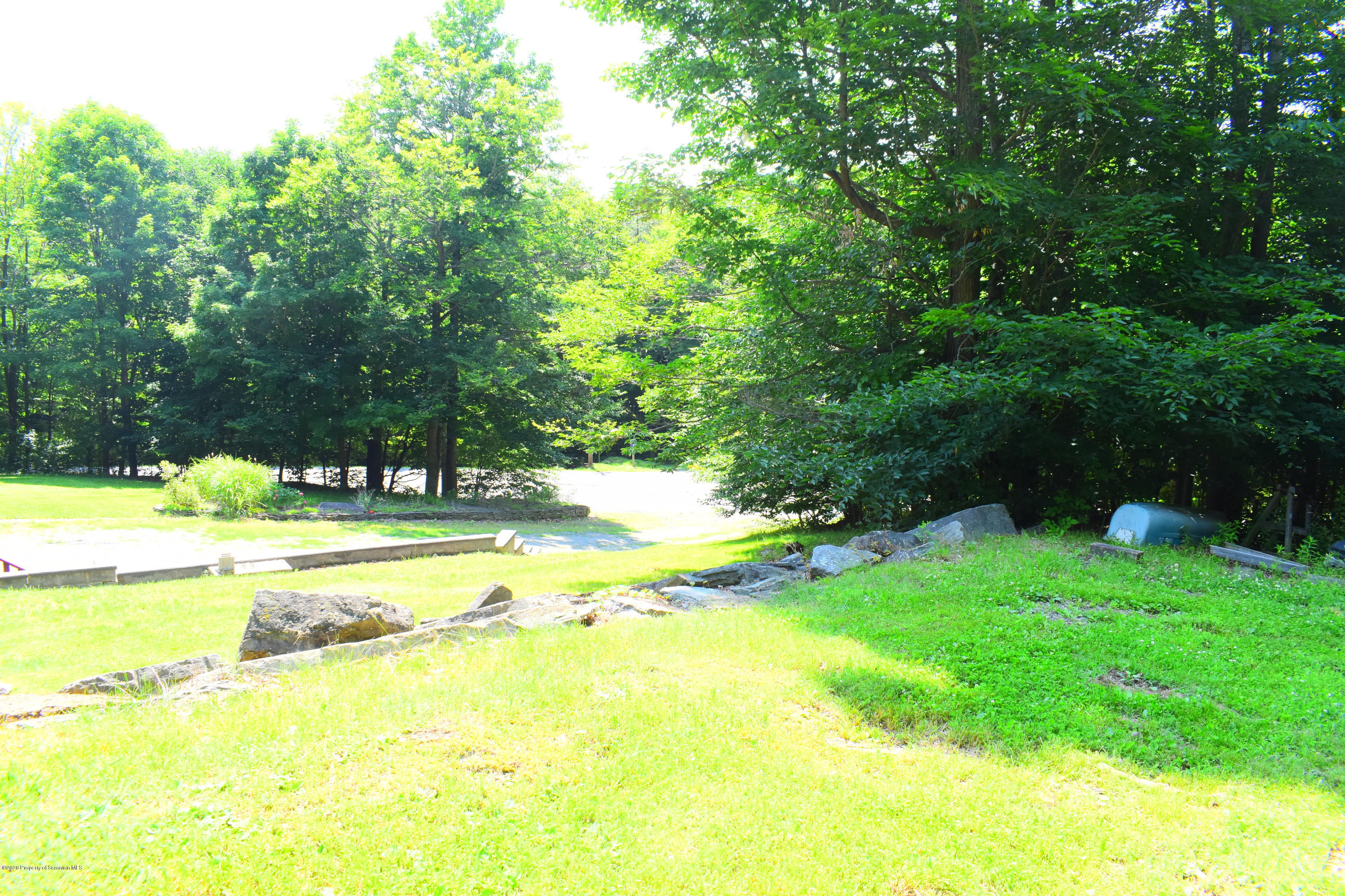 3322 North Road Montrose, PA 18801 - Photo 33 of 38 a view of a swimming pool with a lawn chairs under an umbrella