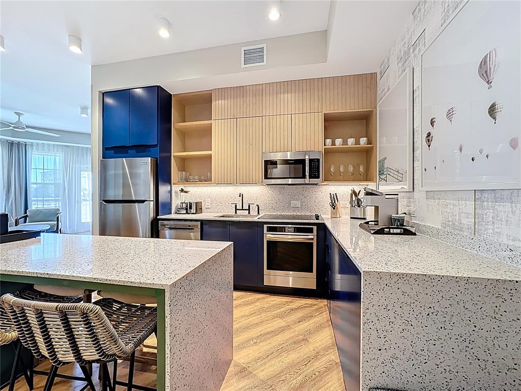 3151 Sunset Walk Drive, Unit 204 Kissimmee, FL 34747 - Photo 11 of 58 a large kitchen with stainless steel appliances granite countertop a stove refrigerator and a sink