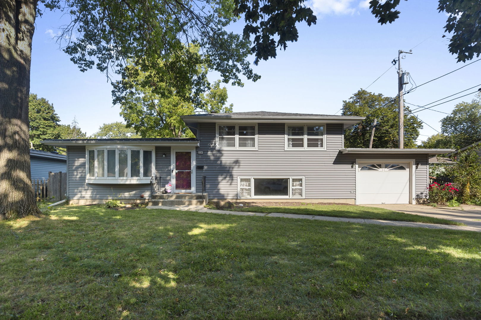 324 Alma Terrace Cary, IL 60013 - Photo 2 of 31 a front view of house with yard and trees in the background
